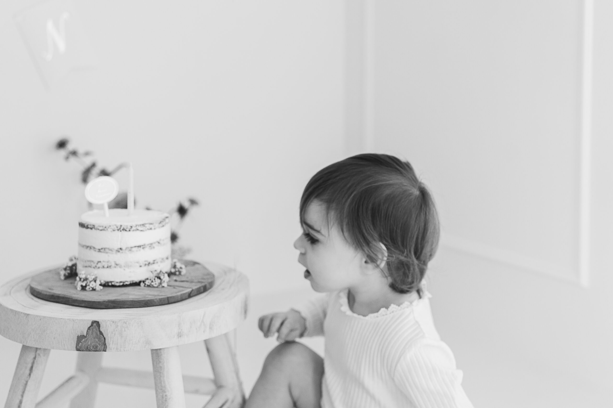 Photo noir et blanc d'un bébé et son gâteau d'anniversare