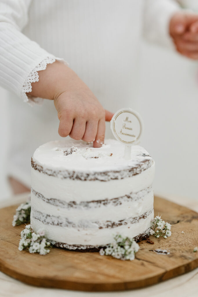 Photo d'un enfant mettant le doigt dans un gâteau d'anniversire