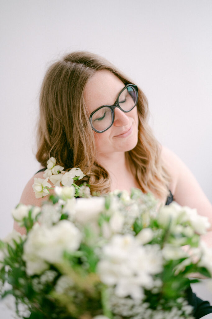 photographe-reims-photo de Julie Chef Photography se tenant assise avec des fleurs blanche à la main