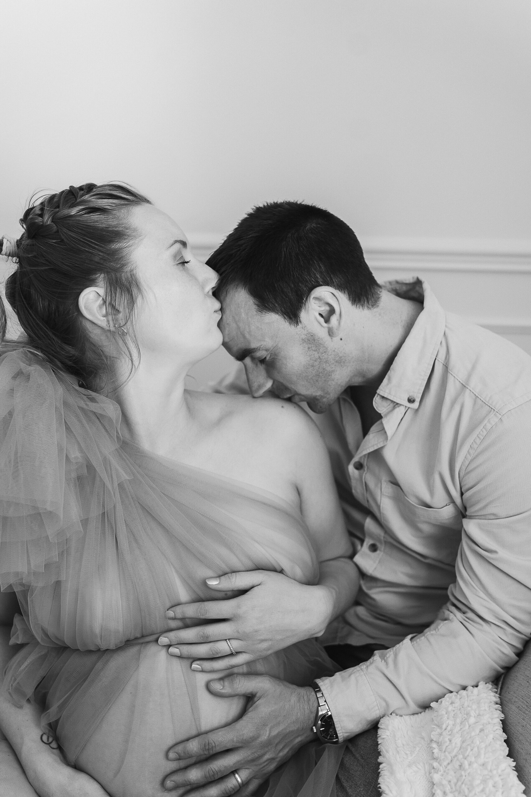 Séance photo de grossesse en studio à Reims – Kévin embrassant l'épaule de Alice