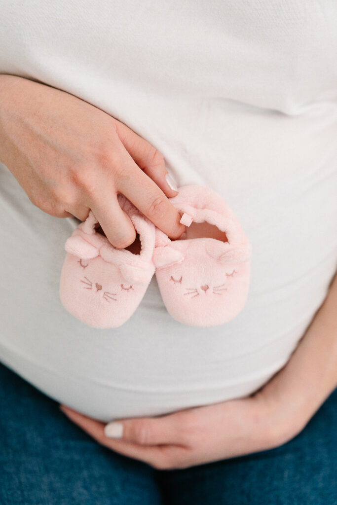 Photo artistique de ventre rond en studio à Reims- petits chaussons de bébé