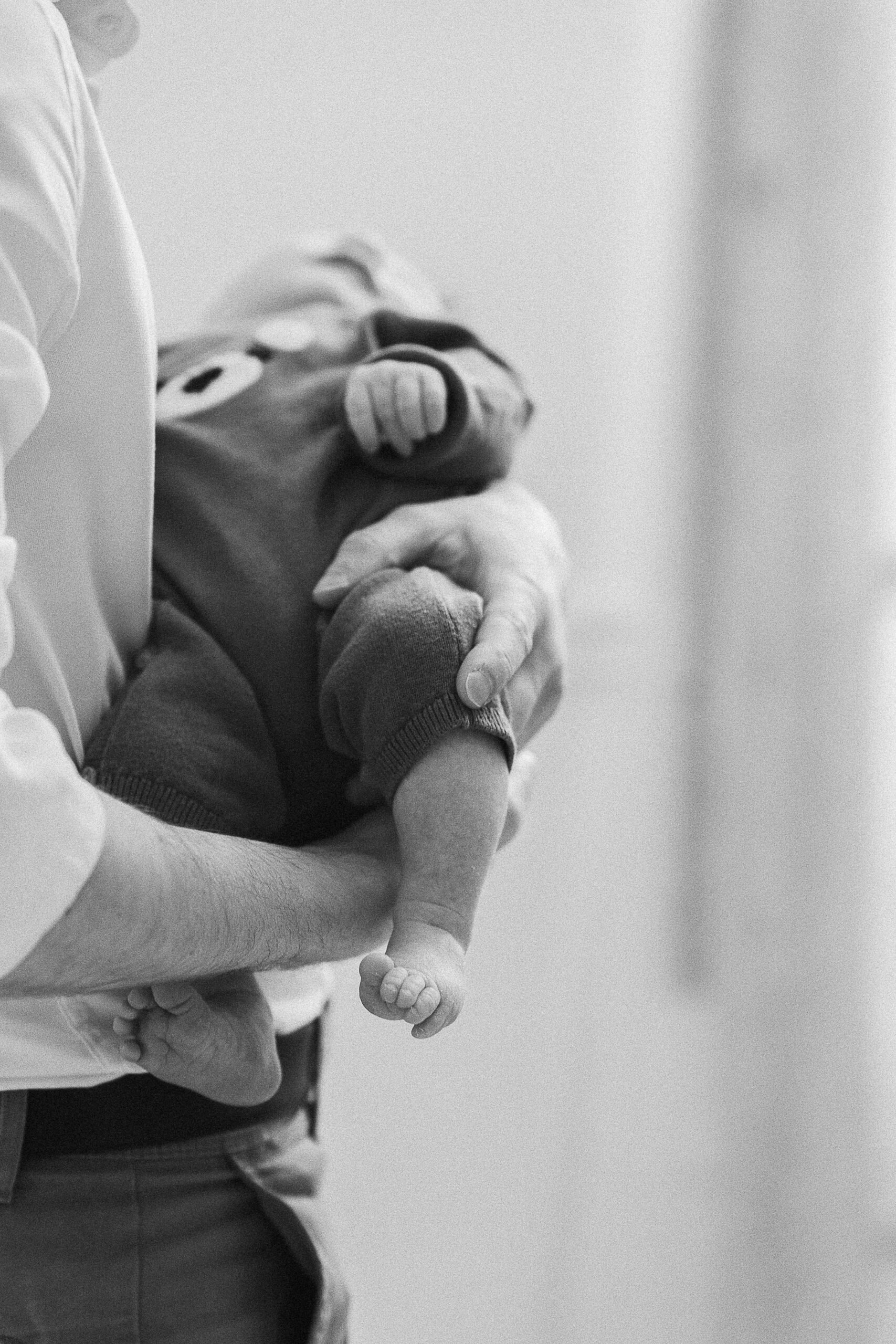 Photographe naissance Reims – papa tenant son bébé dans les bras